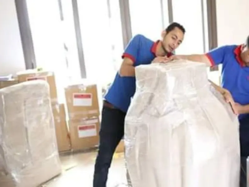الفريق بيغلّف كنبة بالبلاستيك قبل التحميل
